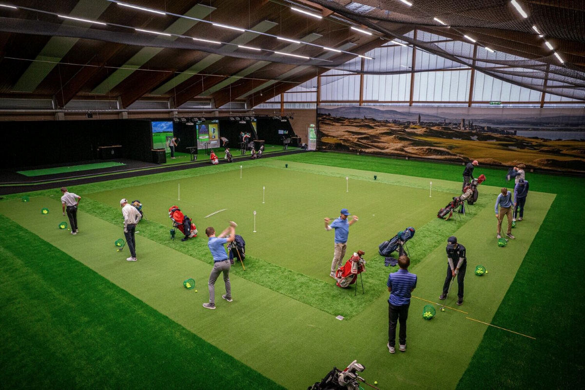 Golfspieler beim Trainieren mit Trackman-Technologie in einer Halle
