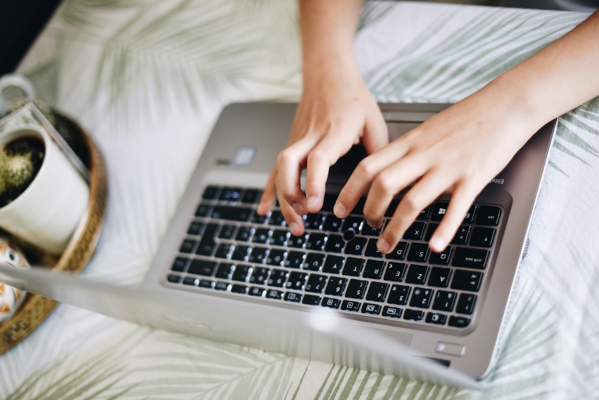 Person schreibt auf einem Laptop