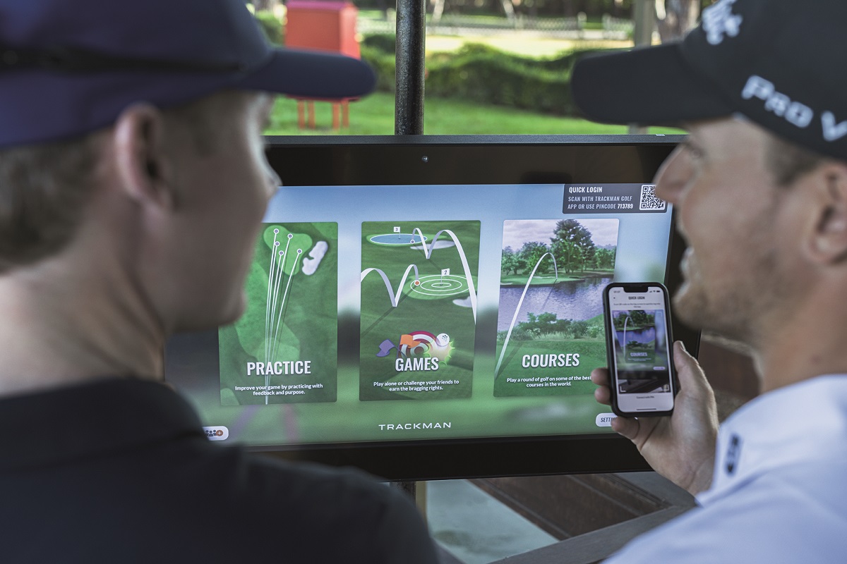 Bild: zwei Golfer vor einem TrackMan-Screen